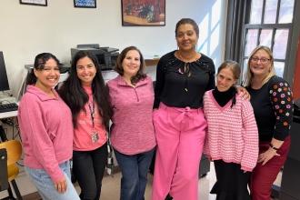 A group of staff at a public school in Queens wear matching pink attire for breast cancer awareness.