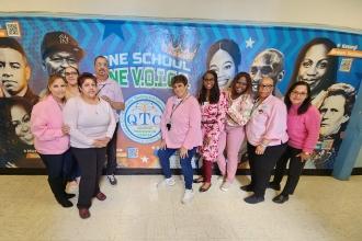 A group of staff at a public school in Queens wear matching pink attire for breast cancer awareness.