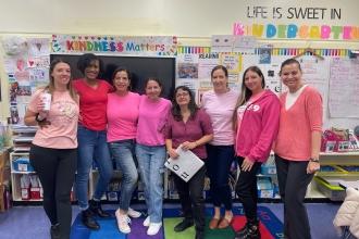 A group of staff at a public school in Brooklyn wear matching pink attire for breast cancer awareness.