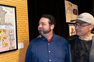 An art teacher on the left shows off his work to his father at the New York City Art Teachers Association/UFT’s Dreams Art Show on May 10.