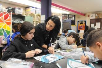 A teacher works with her students in preparation for an art show at IS 34 on Staten Island. 
