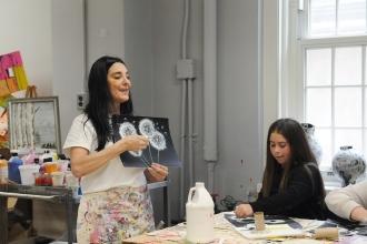 A teacher gives instruction on an art project in preparation for an art show at IS 34 on Staten Island.