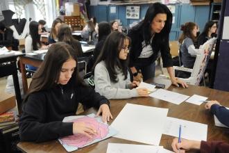 An art teacher works with her students in preparation for an art show at IS 34 on Staten Island.
