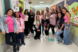 A group of staff at a public school on Staten Island wear matching pink attire for breast cancer awareness.