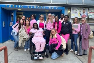 A group of staff at a public school in Manhattan wear matching pink attire for breast cancer awareness.