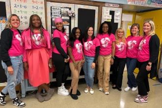 A group of staff at a public school in the Bronx wear matching pink attire for breast cancer awareness.