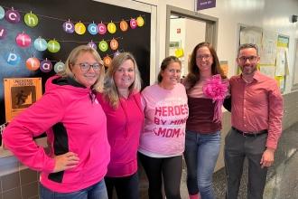 A group of staff at a public school in Queens wear matching pink attire for breast cancer awareness.